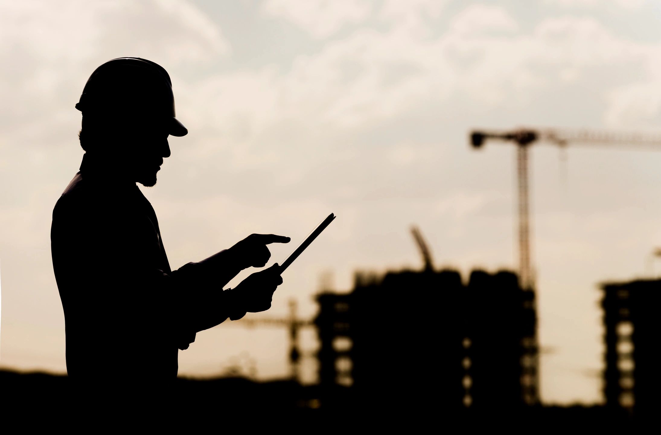 Site manager with hard hat and tablet