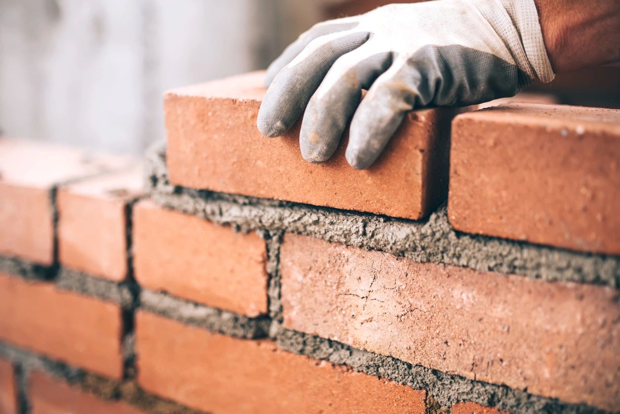 Construction worker laying brick masonry