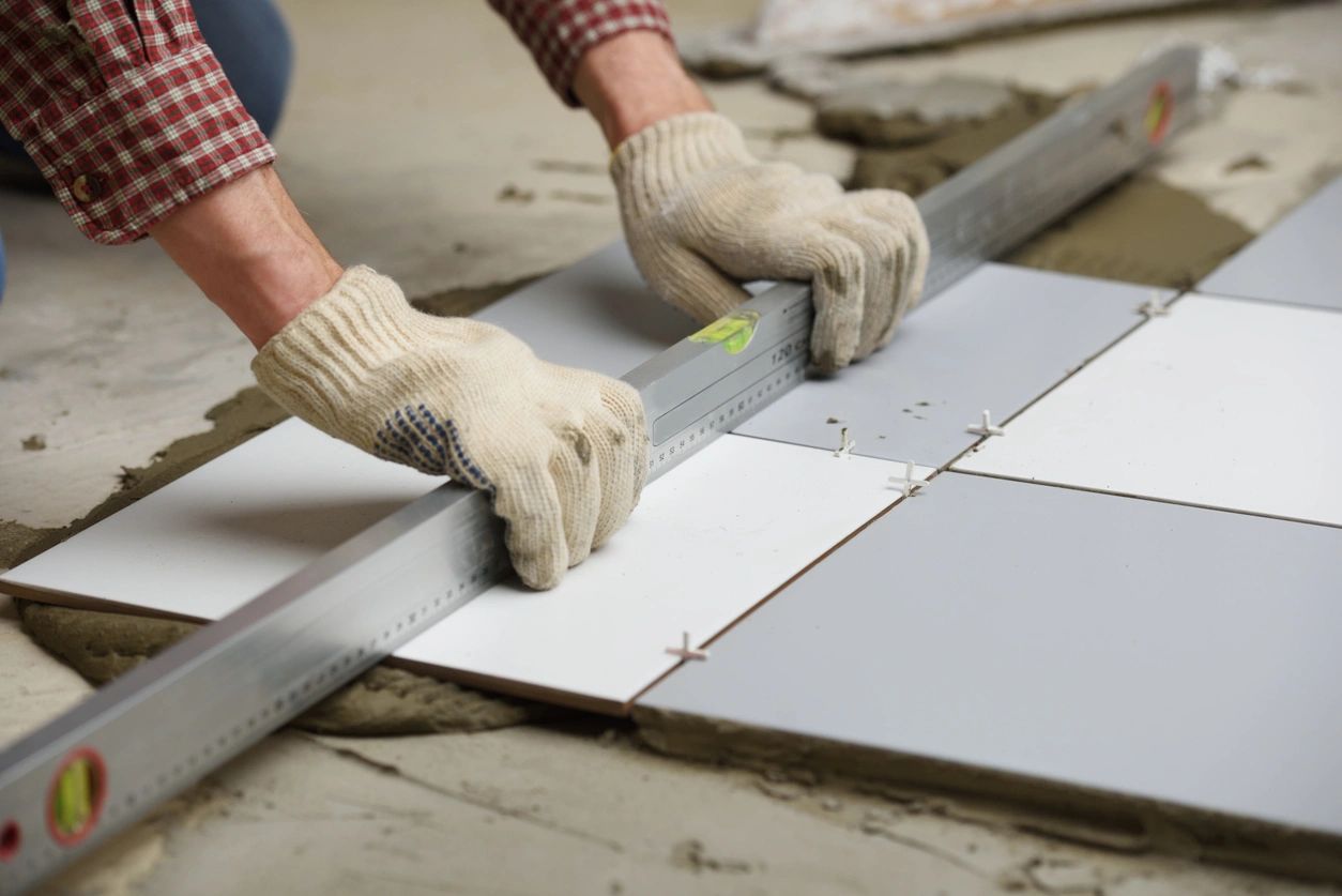 Worker measuring tiles on floor